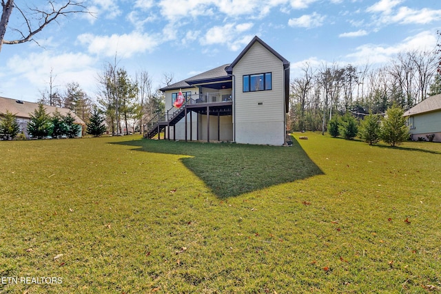 rear view of house featuring a lawn and a deck