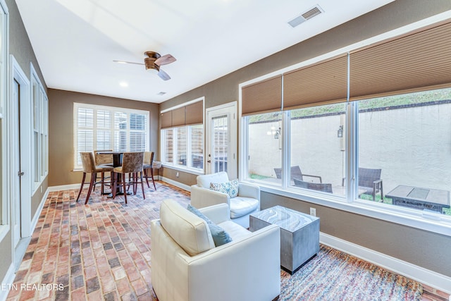 sunroom featuring ceiling fan and visible vents