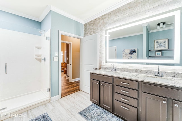 full bath with ornamental molding, a stall shower, and a sink