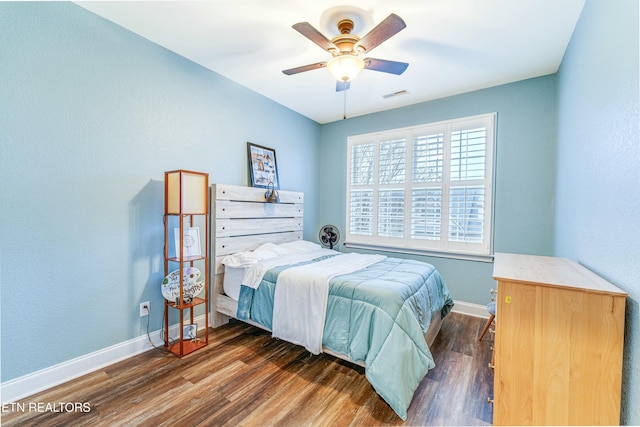 bedroom featuring ceiling fan, dark wood finished floors, visible vents, and baseboards