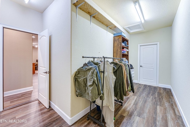 walk in closet featuring wood finished floors and attic access