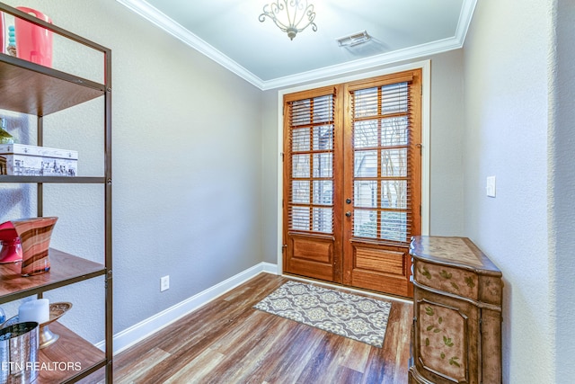 interior space with wood finished floors, visible vents, baseboards, french doors, and crown molding