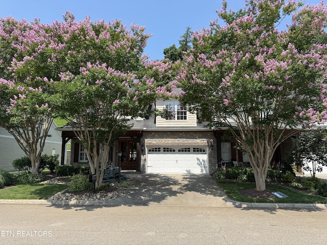 437 Grove Branch Ln, Knoxville, TN 37922 - view of property hidden behind natural elements with stone siding, driveway, a garage, and french doors