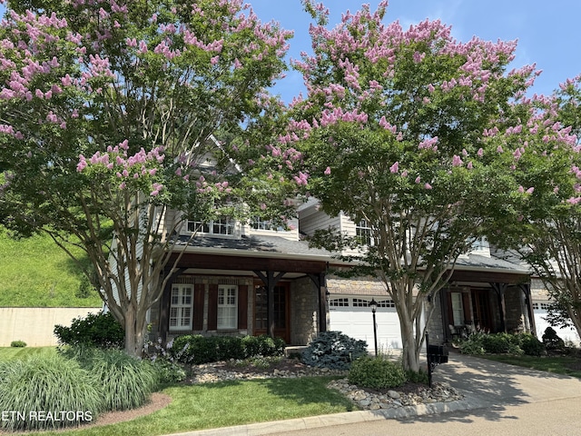 437 Grove Branch Ln, Knoxville, TN 37922 - view of property hidden behind natural elements featuring a garage, stone siding, concrete driveway, and a front lawn