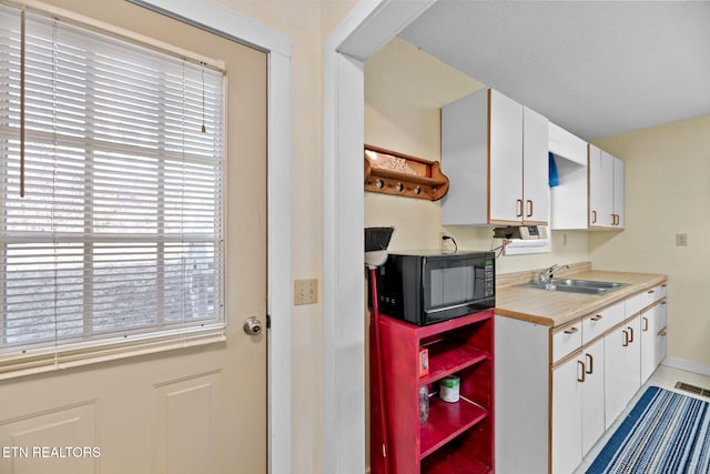 kitchen featuring white cabinetry and sink