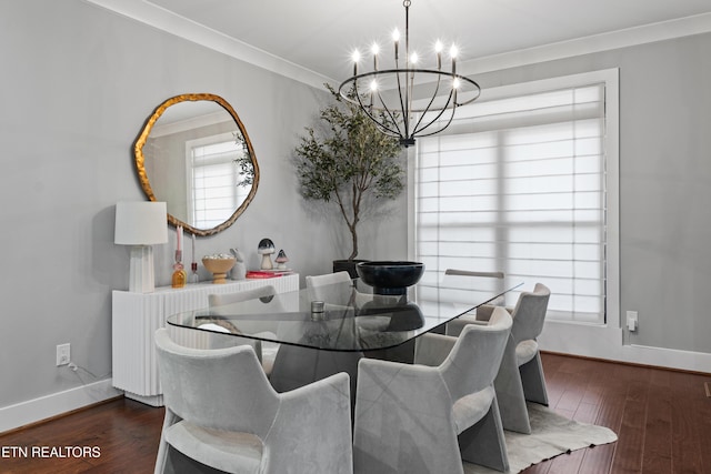 dining area featuring a chandelier, ornamental molding, wood finished floors, and baseboards