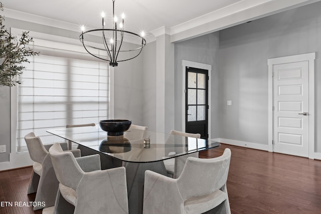 dining room featuring ornamental molding, dark wood-type flooring, baseboards, and an inviting chandelier