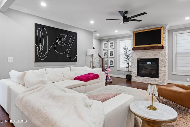 living room featuring a fireplace, recessed lighting, dark wood-type flooring, ornamental molding, and a ceiling fan