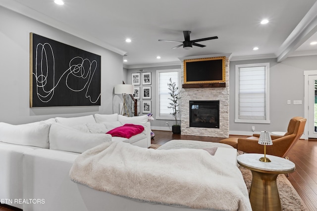 living room with crown molding, recessed lighting, a ceiling fan, a large fireplace, and wood finished floors