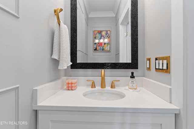 bathroom with ornamental molding and vanity