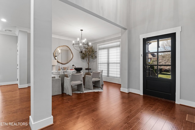 dining space with crown molding, visible vents, an inviting chandelier, baseboards, and hardwood / wood-style flooring