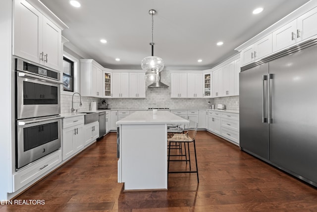 kitchen with glass insert cabinets, stainless steel appliances, a sink, and light countertops