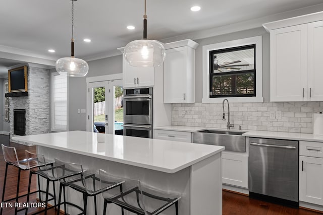 kitchen featuring a breakfast bar, light countertops, appliances with stainless steel finishes, tasteful backsplash, and crown molding