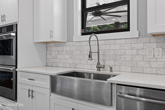 kitchen featuring white cabinetry, tasteful backsplash, appliances with stainless steel finishes, and a sink