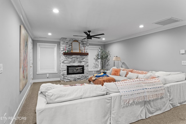 living area featuring a large fireplace, recessed lighting, visible vents, and crown molding