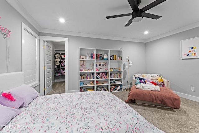 carpeted bedroom with a spacious closet, ornamental molding, recessed lighting, and baseboards