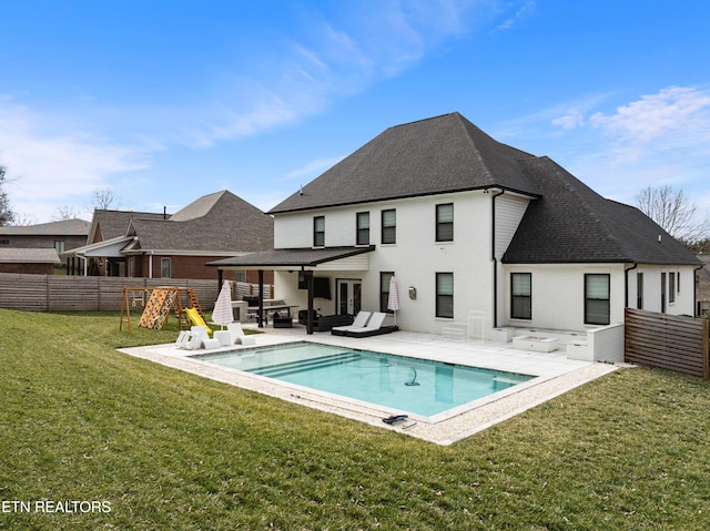 back of property featuring an outdoor hangout area, fence, a yard, a fenced in pool, and a patio area