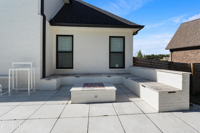 view of patio featuring fence and a fire pit