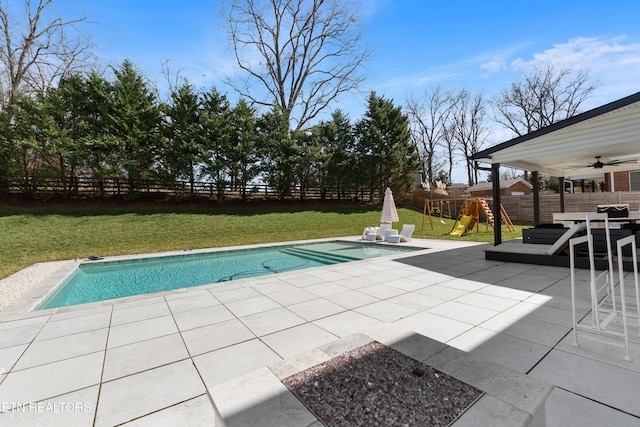 view of swimming pool featuring a patio area, a playground, a fenced backyard, and a fenced in pool