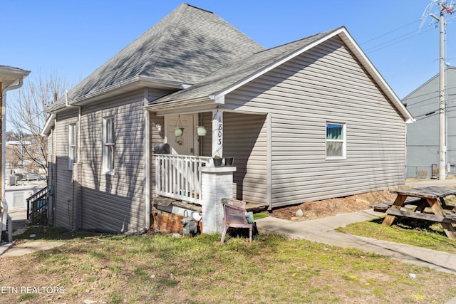 view of front of home featuring a shingled roof and covered porch