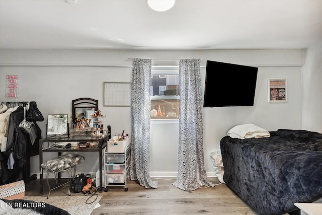 bedroom with wood finished floors and baseboards