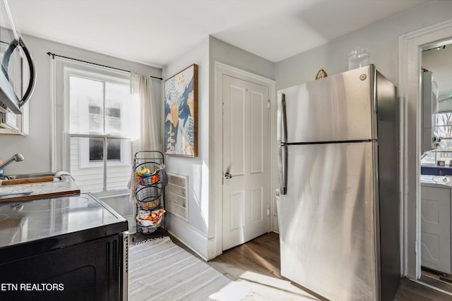 kitchen with light wood-type flooring, visible vents, stainless steel appliances, and a sink