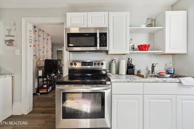 kitchen with stainless steel appliances, white cabinets, a sink, and open shelves