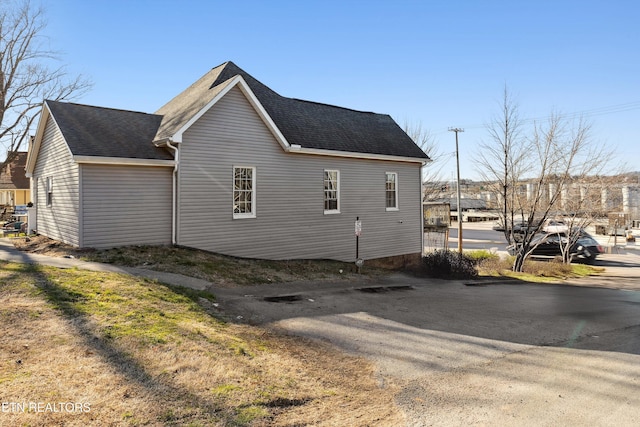 view of property exterior featuring a shingled roof