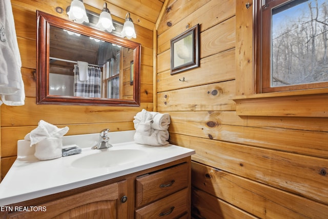 bathroom with a shower with curtain, vanity, and wood walls