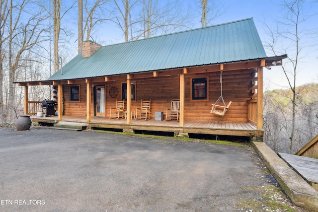 log home featuring covered porch