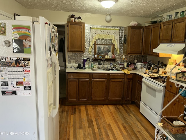 kitchen with dark hardwood / wood-style flooring, sink, a textured ceiling, and white appliances