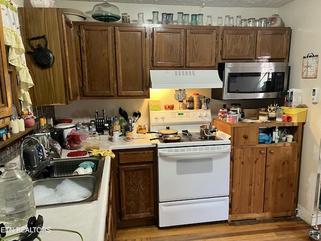 kitchen featuring white electric stove, range hood, sink, and light hardwood / wood-style flooring