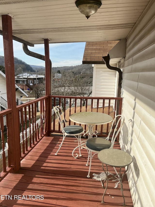 snow covered deck with ceiling fan and a mountain view