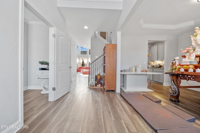 entrance foyer featuring ornamental molding and light wood-type flooring