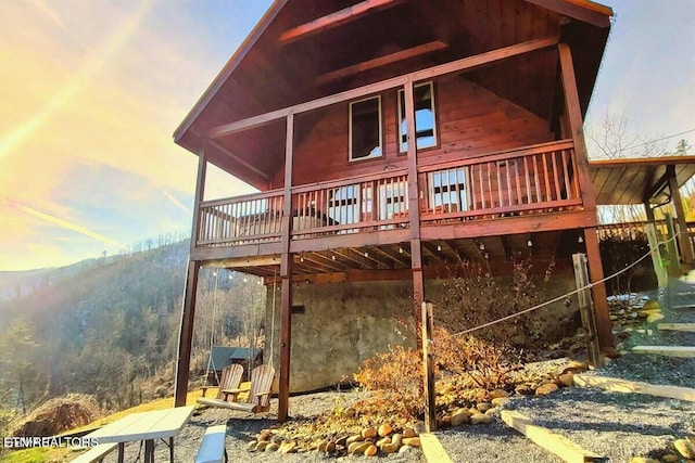 back house at dusk with a deck