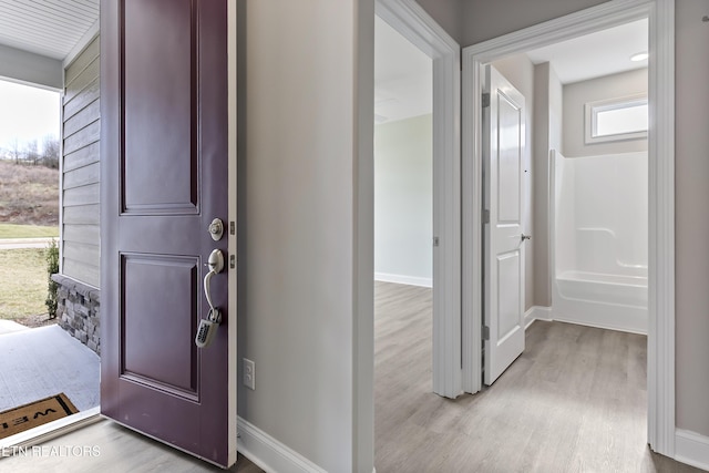 corridor with light hardwood / wood-style floors