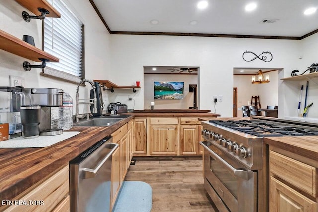 kitchen with ornamental molding, wooden counters, and appliances with stainless steel finishes