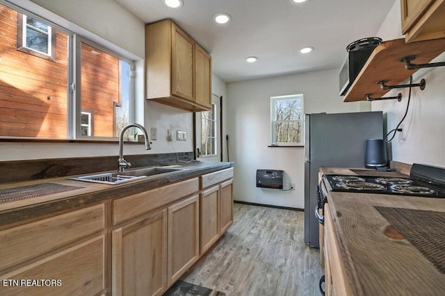 kitchen with sink, light hardwood / wood-style floors, gas stove, and light brown cabinets