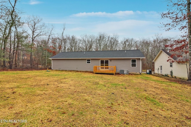 back of property with cooling unit, a yard, and a deck