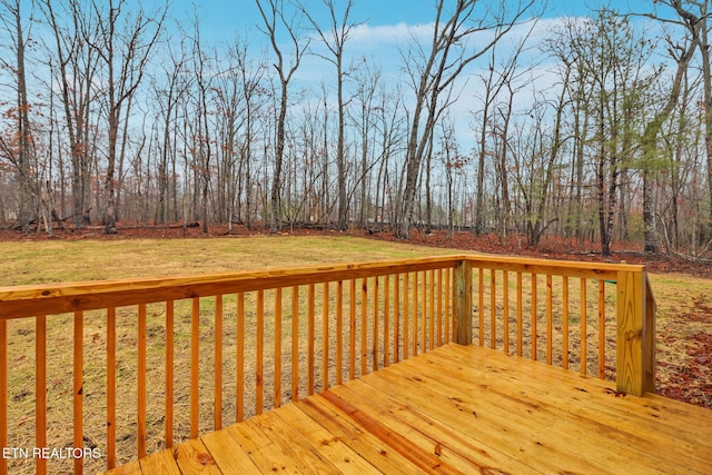 wooden deck featuring a lawn