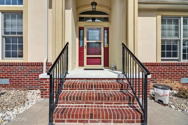 view of exterior entry with brick siding