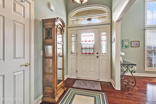 entrance foyer with dark wood-type flooring, visible vents, and baseboards