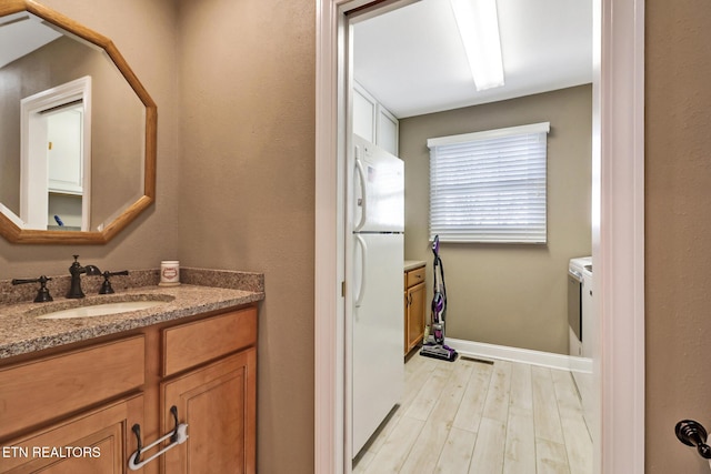 bathroom featuring vanity, baseboards, and wood finished floors