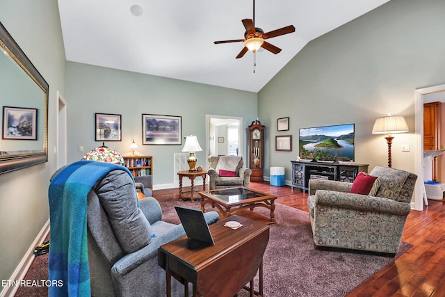 living area with high vaulted ceiling, wood finished floors, visible vents, a ceiling fan, and baseboards