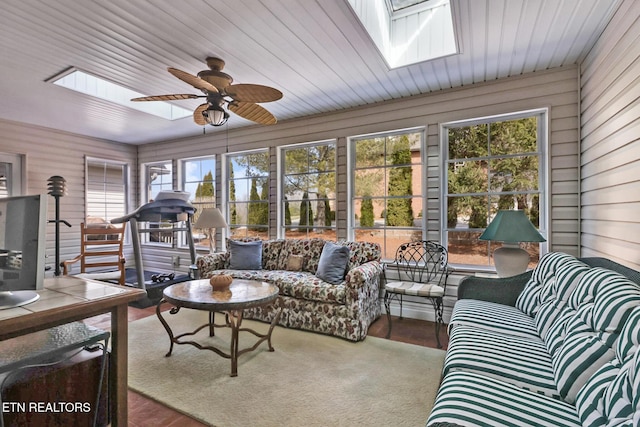 sunroom / solarium with wood ceiling, a skylight, plenty of natural light, and a ceiling fan