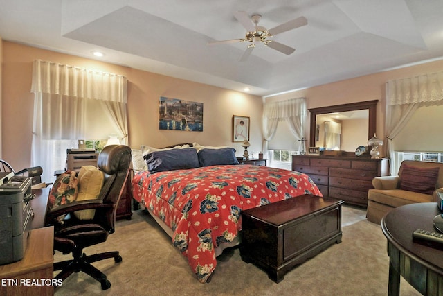 bedroom with a ceiling fan, a tray ceiling, light colored carpet, and recessed lighting