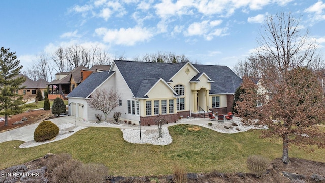 view of front facade featuring a garage, brick siding, driveway, and a front lawn