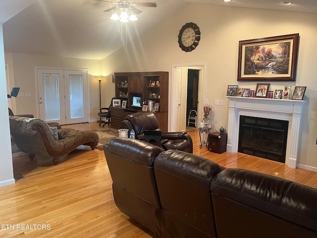 living room featuring ceiling fan, lofted ceiling, and light wood-type flooring