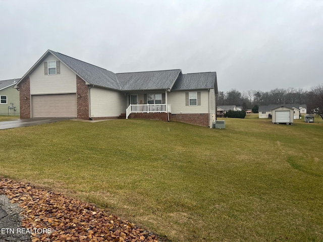 view of front of property with a porch, central AC, a garage, and a front yard