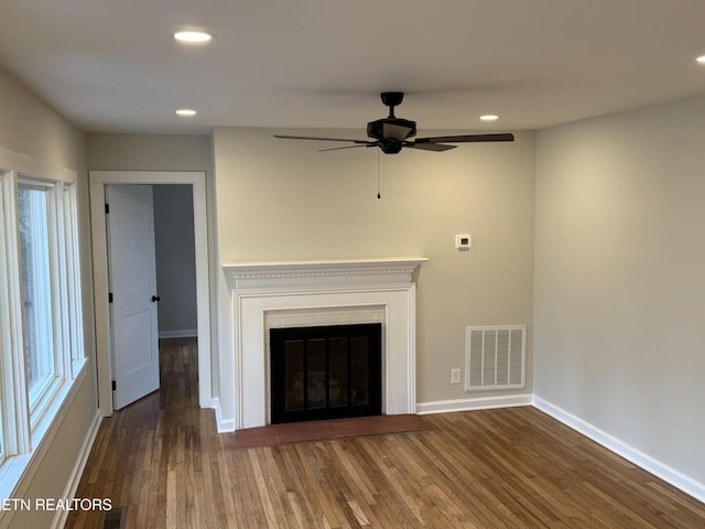 unfurnished living room featuring ceiling fan and dark hardwood / wood-style floors